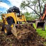 Yellow mini bulldozer working with earth, moving soil and doing landscaping works